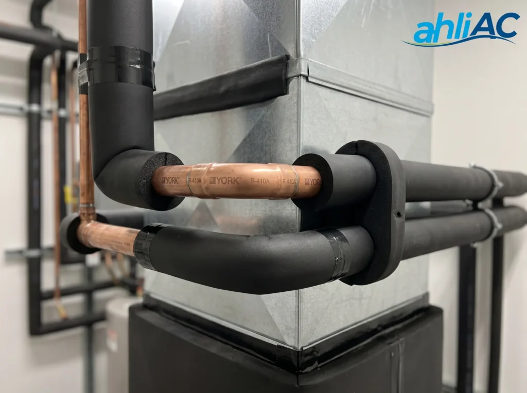 Detail instalasi ducting dan insulasi pipa tembaga yang rapi untuk meminimalkan kebocoran energi dingin pada sistem HVAC York.
